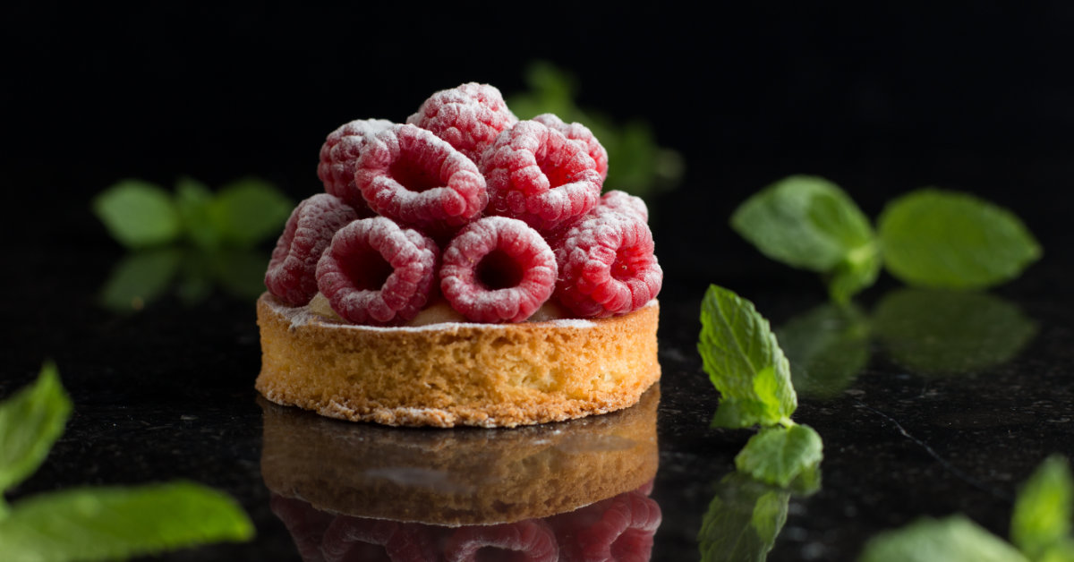 A fancy raspberry dessert on a black background