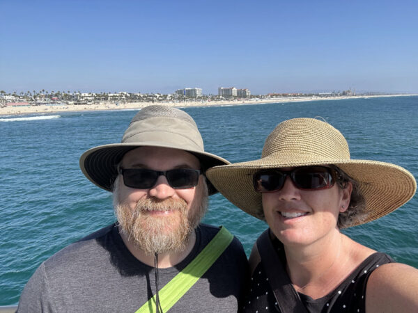 A selfie of me and Mr M on Huntington Beach Pier with the ocean and the beach in the background.